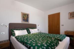 a bedroom with a green blanket on a bed at Chalet Pradat in Arabba
