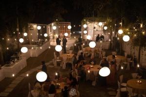 a group of people sitting at tables at a party at night at AruBhi Cottage in Dehradun +26 photos