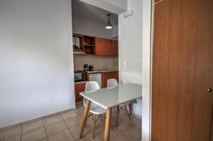 a small kitchen with a white table and chairs at Astacos Studios in Paleokastritsa