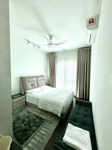 a bedroom with a bed and a ceiling fan at Livistona Luxe Apartment in Permatang Pauh