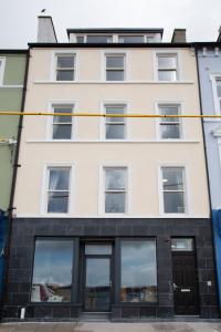 a large white building with windows at Unit 1 Island View Apartments - Town Centre Walk To Everything in Cobh