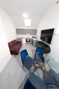 a living room with a glass table and blue chairs at Unit 1 Island View Apartments - Town Centre Walk To Everything in Cobh