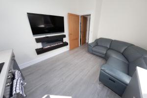 a living room with a couch and a flat screen tv at Unit 1 Island View Apartments - Town Centre Walk To Everything in Cobh
