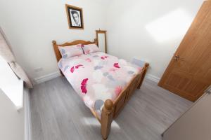 een kleine slaapkamer met een bed met een bloemdekbed bij Unit 1 Island View Apartments - Town Centre Walk To Everything in Cobh