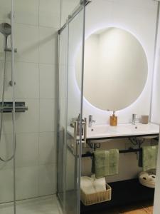 une salle de bain avec un lavabo et une douche dans l'établissement Les Remparts, à Châteauneuf-du-Faou 2 autres photos