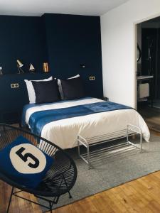 une chambre avec un grand lit et une chaise dans l'établissement Les Remparts, à Châteauneuf-du-Faou