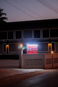 un panneau devant un bâtiment la nuit dans l'établissement BK Hotel, à Mae Sariang