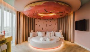 ドルドレヒトにあるファン デル ファルク ホテル ドルドレヒトの天井に絵画が描かれたベッド付きの部屋