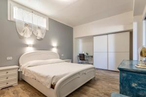 1 dormitorio con cama blanca y vestidor en Domo Minore, en Palmadula