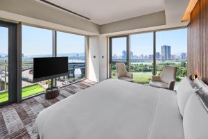 una camera d'albergo con un letto grande e una TV a schermo piatto di Suz & Catorze Taipei, a Tribute Portfolio Hotel a Taipei