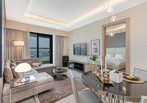 a living room with a couch and a dining room at Your Story of Luxury Begins Here in Dubai