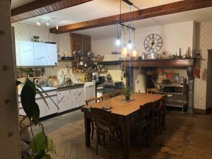 uma grande cozinha com uma mesa de madeira e cadeiras em L'AUBERGE DES PYRENEES em La Barthe-de-Neste