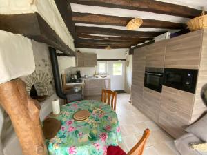 a dining room with a table and a kitchen at Au Chêne Gauthier in Pouillé