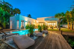 a home with a swimming pool and a house at Glamorous Waterfront Canal Home w Pvt Dock & Pool in Fort Lauderdale