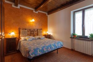 a bedroom with a bed and two windows at Agriturismo Collelignani in Spoleto
