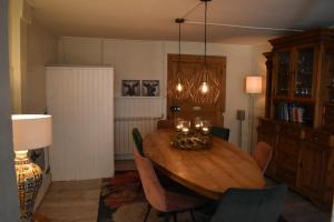 a dining room with a wooden table and chairs at L'Arc en Ciel in Bleurville