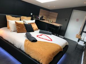 a bedroom with a large bed with a red ribbon on it at Playroom et Nuit Insolite in Aubie-et-Espessas