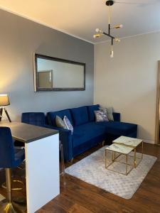 sala de estar con sofá azul y mesa en Apartament Glamour, en Toruń