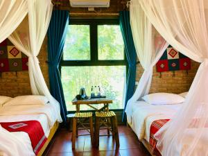 two beds in a room with a window at Pu Luong Riverside Lodge in Hương Bá Thước