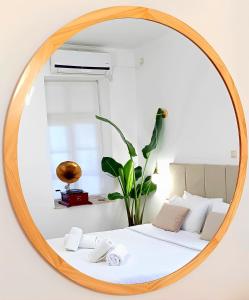 um espelho que reflecte uma cama num quarto em Apeiron Acropolis Suites em Atenas