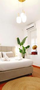 een slaapkamer met een groot bed en een plant bij Apeiron Acropolis Suites in Athene