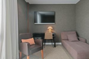 sala de estar con sofá, silla y escritorio en Hotel Sant Just en Sant Just Desvern