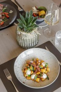 a table with plates of food and a bowl of food at Belia Lofts - ADULTS ONLY - Apartments in Appiano sulla Strada del Vino