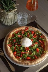 a pizza sitting on a plate on a table at Belia Lofts - ADULTS ONLY - Apartments in Appiano sulla Strada del Vino