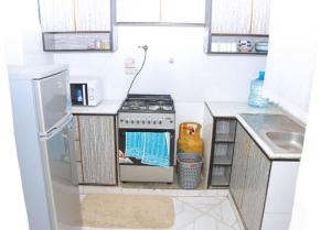 a kitchen with a stove and a sink at Lulu Stays 2 Bedroom in Nyahururu +5 photos
