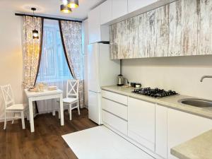 a white kitchen with a sink and a table at Апартаменти в ЖК Яровиця біля ТРЦ Промінь in Lutsk