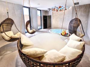 a room with three hanging chairs and a table at Hotel Lomnica in Tatranská Lomnica