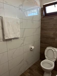a bathroom with a toilet and a window and a towel at Stoyko's Guest House in Pomorie