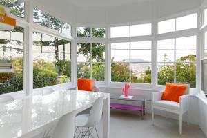 a white room with windows and a table and chairs at Kate Owen Art House in Hobart