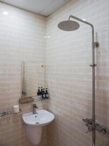 een badkamer met een wastafel en een douche bij Thuận Hòa Hotel in Xuan An