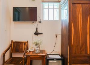 een kamer met een tv en een bureau met een stoel bij Thuận Hòa Hotel in Xuan An