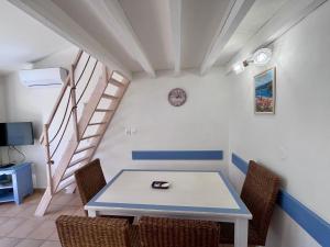 uma mesa e cadeiras num quarto com uma escada em Charmant appartement Village Restanques de Saint Tropez em Grimaud