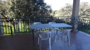uma mesa branca e cadeiras numa varanda em Shivanda, Habitaciones en Centro de Bienestar en la Naturaleza em Pioz