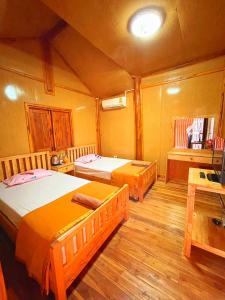 una camera con 2 letti in una stanza con pavimenti in legno di จันทวี รีสอร์ท a Changwat Prachuap Khiri Khan