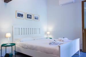 a bedroom with a white bed with two tables and two lamps at Villa Onedo in Abbadia Lariana