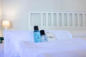 two bottles of sunscreen and towels on a bed at Villa Onedo in Abbadia Lariana