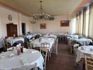 a dining room with white tables and chairs at Hotel La Rama in Lazise