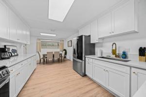 una cocina con armarios blancos y electrodomésticos de acero inoxidable en upgraded 4bd house with huge backyard, en Rowland Heights