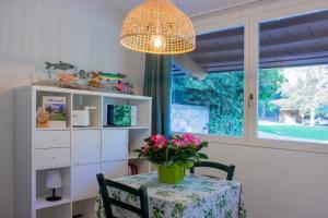 a dining room with a table with a vase of flowers at Villa Onedo in Abbadia Lariana