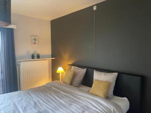um quarto com uma cama grande e almofadas amarelas em Vakantiehuis Bloemmolenkaai em Diksmuide