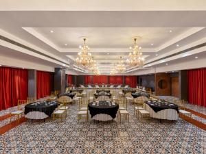 a banquet hall with tables and chairs and chandeliers at Zone Connect by The Park Indore in Indore