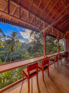 a room with chairs and a view of the forest at Made Punias Jungle Paradise in Ubud