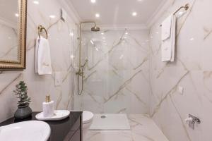 a white bathroom with a shower and a sink at Vivaldi in Dubrovnik