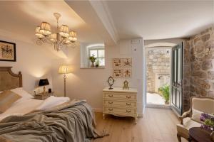 um quarto com uma cama, uma cómoda e uma janela em Vivaldi em Dubrovnik