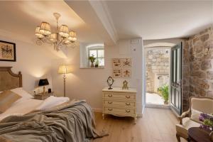 a bedroom with a bed and a dresser and a window at Vivaldi in Dubrovnik