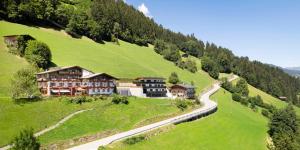 un edificio su una collina vicino a una strada di Gasthof Pension Berghof a Hippach